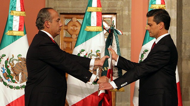 PHOTO: Mexico's outgoing president, Felipe Calderon, left, gives a Mexican flag to president-elect Enrique Pena Nieto during the official transfer of command ceremony at the National Palace in Mexico City, Saturday Dec. 1, 2012.
