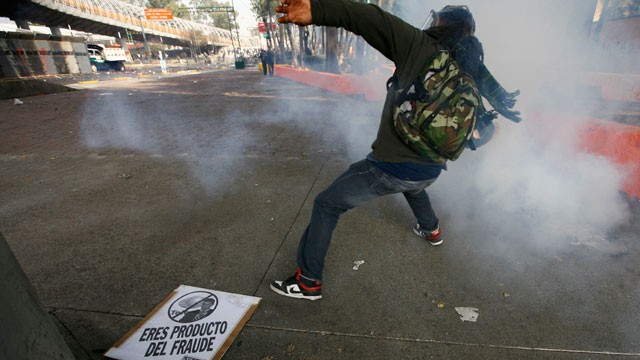 PHOTO:&nbsp;A demonstrator throws a stone to police during protests against new Mexican President Enrique Pena Nieto's rule, outside the National Congress, in Mexico City, Saturday, Dec. 1, 2012.