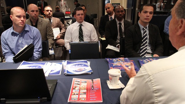 Veterans listen as a representative from White Rose Foods, foreground right, talks about their agency during a job fair introducing veterans to careers in the security and private investigations industry at Yankee Stadium in the Bronx borough of New York.