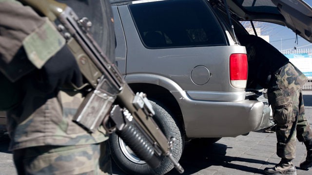 PHOTO:Â Soldiers search a vehicle at the Juarez Avenue border crossing into the USA on January 14, 2009 in Ciudad Juarez, Mexico. Critics of immigration reform say that new laws will make it easier for Mexican cartels to operate in the U.S.