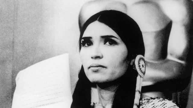 PHOTO: 27th March 1973: Sacheen Littlefeather (actor Maria Cruz in Native American makeup) holds a written statement from actor Marlon Brando refusing his Best Actor Oscar on stage at the Academy Awards, Los Angeles, California.