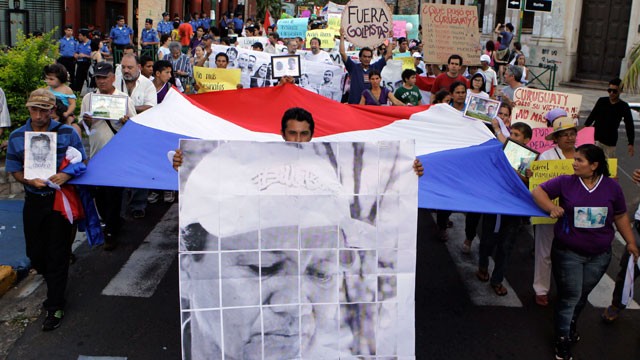 PHOTO:&nbsp;Activists, one carrying a sign with an image of killed peasant leader Vidal Vega, march during a demonstration in Asuncion, Paraguay, Monday, Dec. 10, 2012. Demonstrators asked for clarification of the murder of Vega and the massacre of Curuguaty.