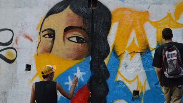 PHOTO:&nbsp;Jesus Garcia from the Chavista youth collective Antimantuanos paints a patriotic mural in Caracas.  Young Chavez supporters say they will support the revolution no matter who is at the helm.