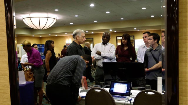 PHOTO: Robert Orkin, of the company TxT-Alert, third from left, talks with job seekers during a job fair held by National Career Fairs, in Fort Lauderdale, Fla.