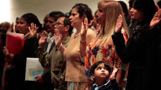 PHOTO:&nbsp;Solemnly raising his hand, Shamir Aijaz, 5, joins with the rest of the crowd as his mom Fariha Aijaz, right, to take the oath of citizenship Monday Dec. 10, 2012, in Germantown, Tn. during a special naturalization ceremony at Houson High School.