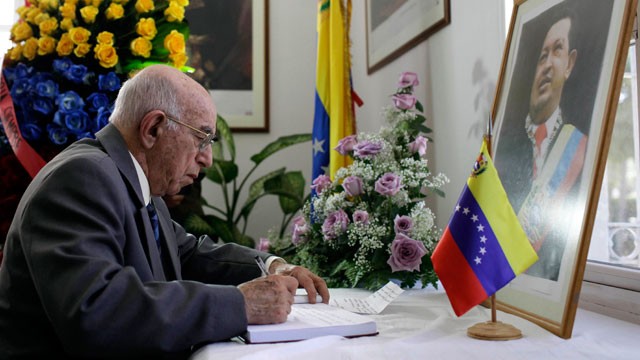 PHOTO: Cuba's Vice President of the Council of State, Jose Ramon Machado Ventura, writes in a book of condolence for Venezuela's late President Hugo Chavez