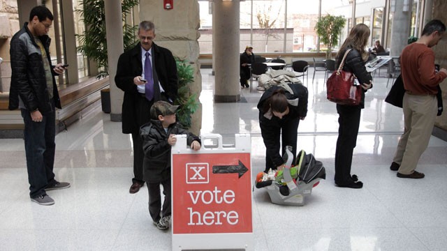 PHOTO: Cole Cryan, 4, leans on a sign directing voters while waiting with his mother, Monday, Nov. 5, 2012, at the Wood County Court House in Bowling Green, Ohio.