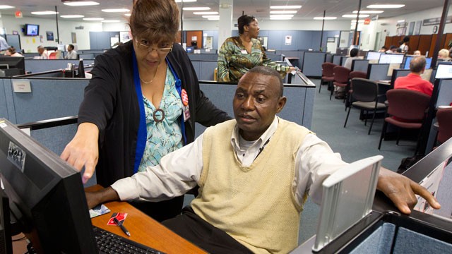 PHOTO: WorkForce One staffer Rose Capote-Marcus works with a client, Pen Osuji as he works on job applications.
