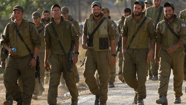 Israeli soldiers march in a gathering area near the Israel Gaza Strip border, in southern Israel, Sunday, Nov. 18, 2012.