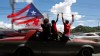 People ride atop a vehicle waving a Puerto Rican flag during elections in San Juan, Puerto Rico, Tuesday, Nov. 6, 2012. Puerto Ricans are electing a governor as the U.S. island territory does not get a vote in the U.S. presidential election.