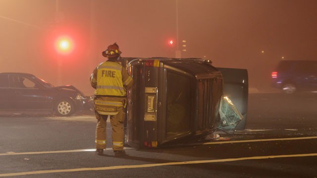 PHOTO: A Roseville Fire Department firefighter looks over an overturned vehicle after a collision at Blue Oaks Boulevard and Woodcreek Oaks Boulevard in Roseville, California on 11/26/2011