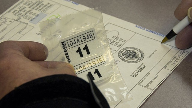 PHOTO:&nbsp;A person fills out paperwork for Oregon license plate stickers.