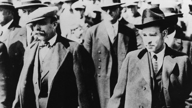 PHOTO: Italian anarchists Nicola Sacco (1891 - 1927) (R) and Bartholomeo Vanzetti (1888 - 1927) (L) walking in a crowd handcuffed after being accused of the murder of a paymaster and a guard in Braintree, Massachusetts.