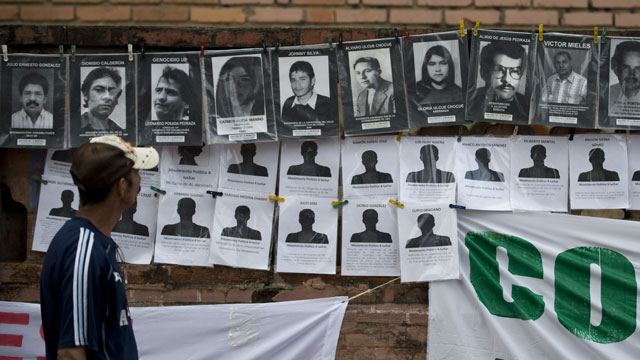 PHOTO: A man looks at portraits of victims during the State-Sponsored Crime Victims International Day in Cali, Colombia.