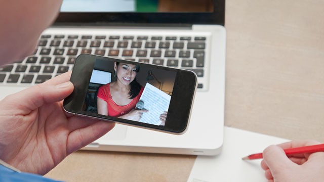 PHOTO: A woman video chats with another woman on a smartphone.