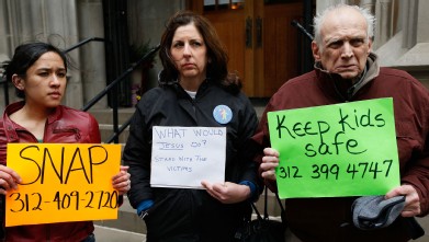 PHOTO: Protesters hold signs with the number for the Survivors Network of those Abused by Priests (SNAP).