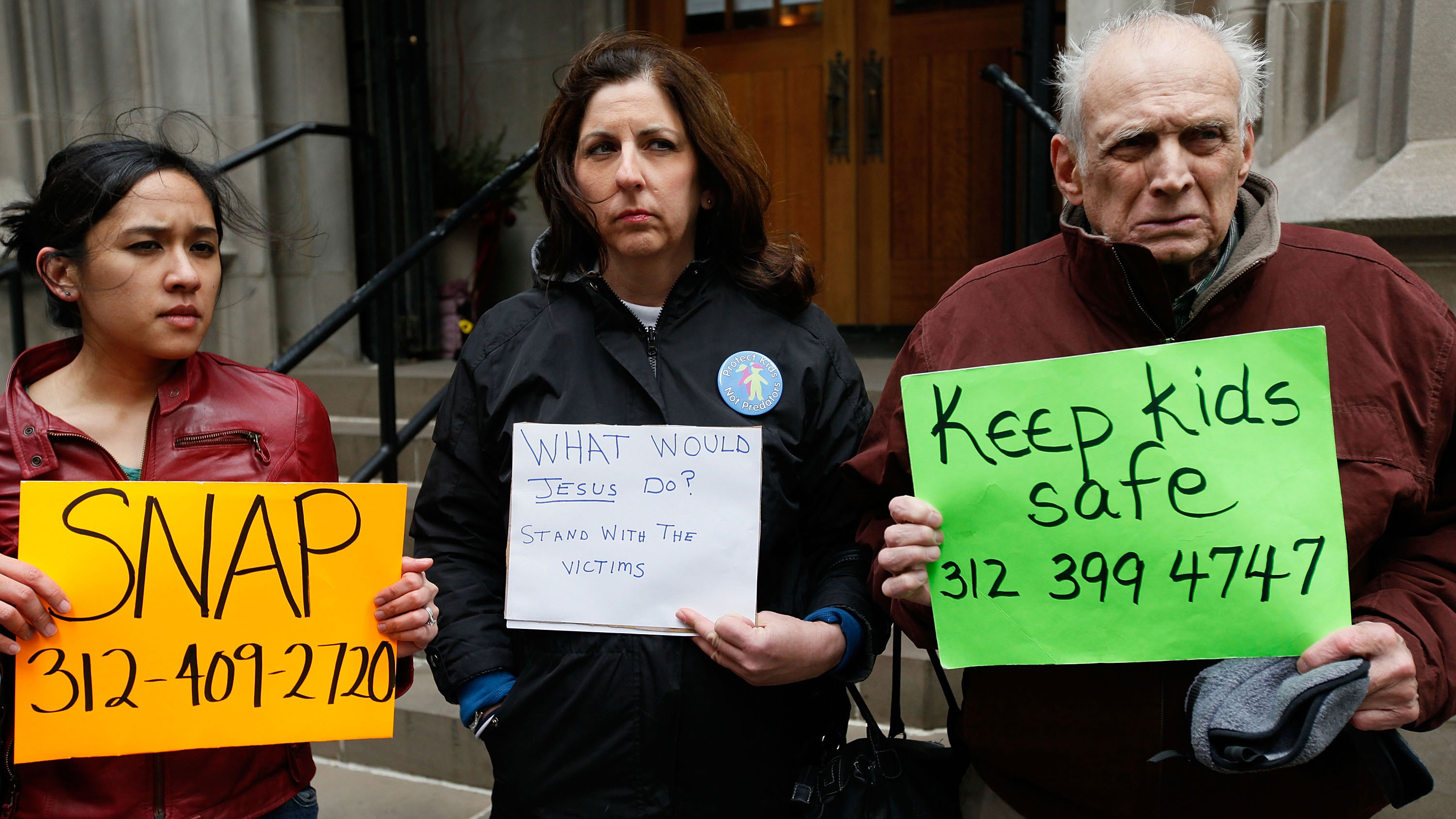 PHOTO: Protesters hold signs with the number for the Survivors Network of those Abused by Priests (SNAP).