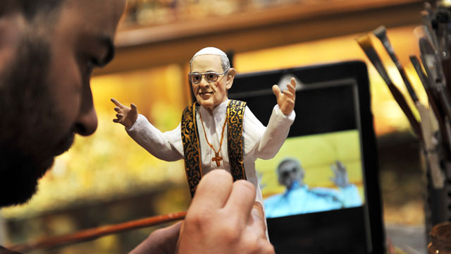 PHOTO: Artisan Genny Di Virgilio paints a hand-crafted figurine of Pope Francis.