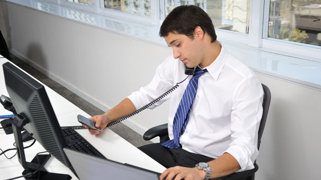 PHOTO:&nbsp;A man multitasks at an office.