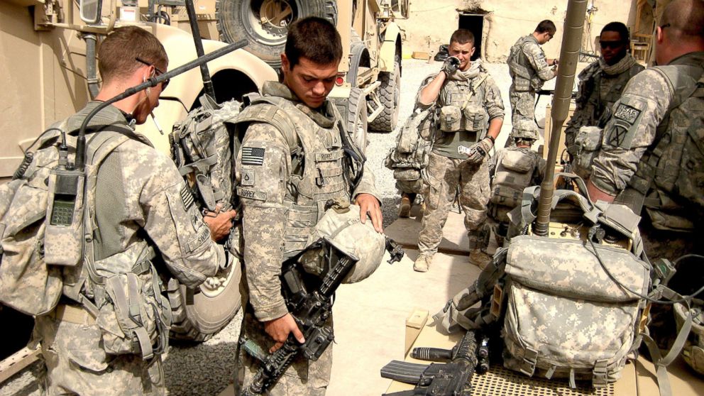 PHOTO: 10th Mountain Division cavalry scouts prepare to patrol in Kandahar, Afghanistan, in 2010 by checking gear including electronic jammers to defeat radio-detonated hidden bombs.