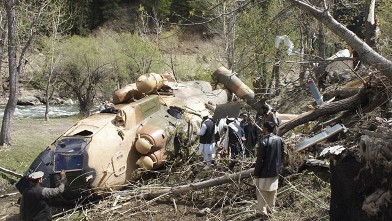PHOTO: Afghan officials investigate the scene May 11, 2011, after an Afghan Defense Ministry helicopter crashed when it hit a tree about 300 yards from the building housing governor Jamalludin Badar in the northeastern province of Nuristan, Afghanistan.
