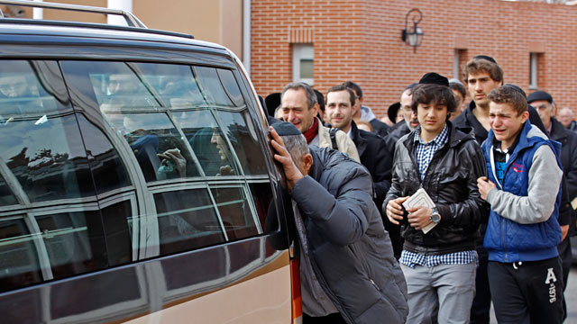PHOTO: Mourners follow the hearse carrying the coffins of the victims following a ceremony at the Ozar Hatorah Jewish school.