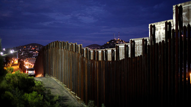 PHOTO: The US and Mexican border wall is illuminated at night, July 6, 2012, in Nogales, Arizona.
