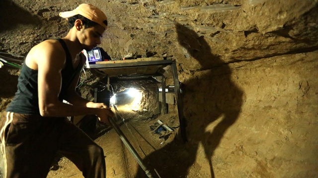 PHOTO: A Palestinian man repairs the entrance of a bombed smuggling tunnel linking the Gaza Strip to Egypt in Rafah, on November 29, 2012.