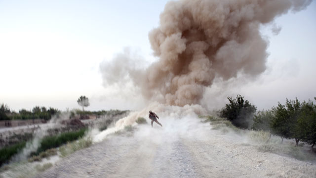 PHOTO: US Marine Sergeant Anthony Zabala runs to safety as an IED explodes in Garmsir district of Helmand Province, Afghanistan.