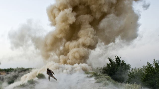 PHOTO: A US Marine runs to safety moments after an IED blast in Garmsir district of Helmand Province in Afghanistan.