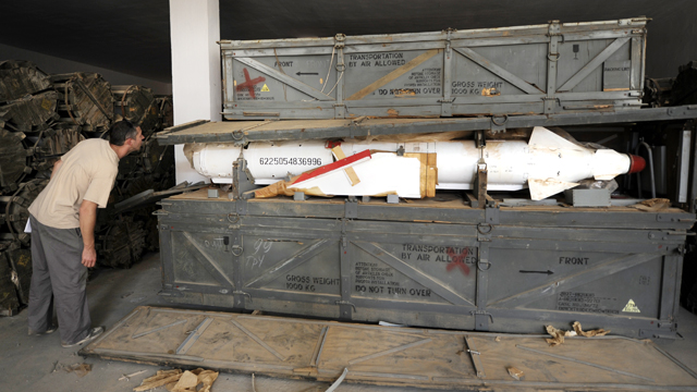 PHOTO: A Libyan man looks at a missile in a wooden crate in an ammunition storage bunker some 100kms south of Sirte, Oct. 26, 2011, where at least some 80 ammunition bunkers are believed to be located.