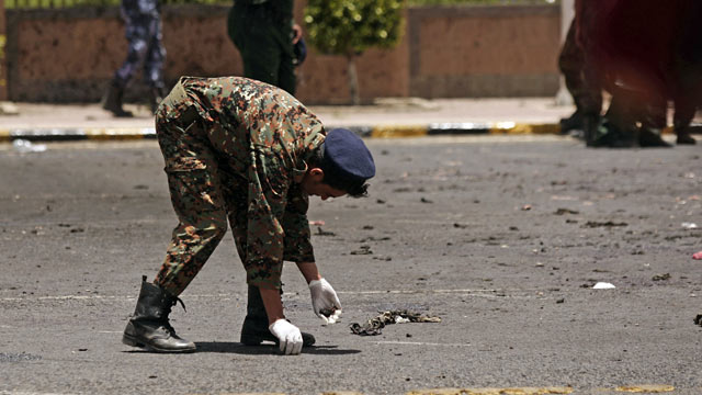 PHOTO: A policeman collects evidence at the site of a suicide bomb attack at a parade square in Sanaa, Yemen, May 21, 2012.