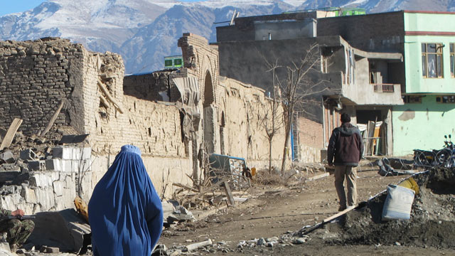 PHOTO: A lone woman in a burqa walks past the rubble from a November 23 suicide truck bomb in the capital of Wardak province, Dec. 2, 2012.