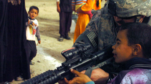 PHOTO A U.S. Army captain gives an Iraqi boy a peek through the ACOG on his M-4 carbine assault rifle in the village of Sudoor, Diyala, Iraq