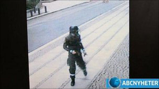 PHOTO: Anders Behring Breivik is filmed by CCTV cameras wearing a police uniform and holding a gun as he walks away from a car after placing a bomb in Oslo.
