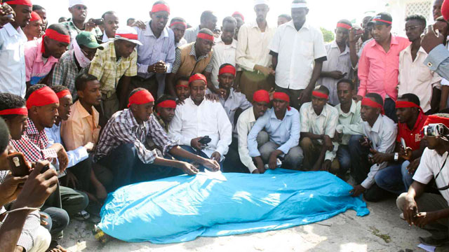 PHOTO: Fellow journalists crowd around the body of Abdisalam Hiis who was murdered in Mogadishu on December 18, 2011.