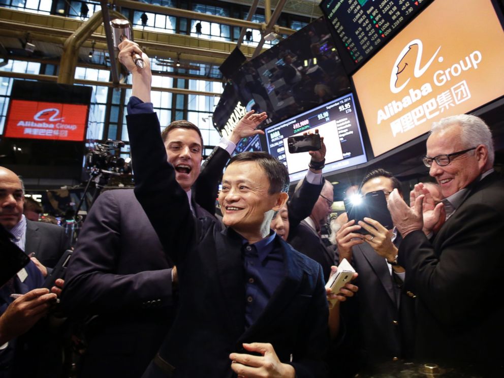 PHOTO: Alibaba founder Jack Ma, center, raises a ceremonial mallet before striking a bell during the companys IPO at the New York Stock Exchange, in New York, Sept. 19, 2014.