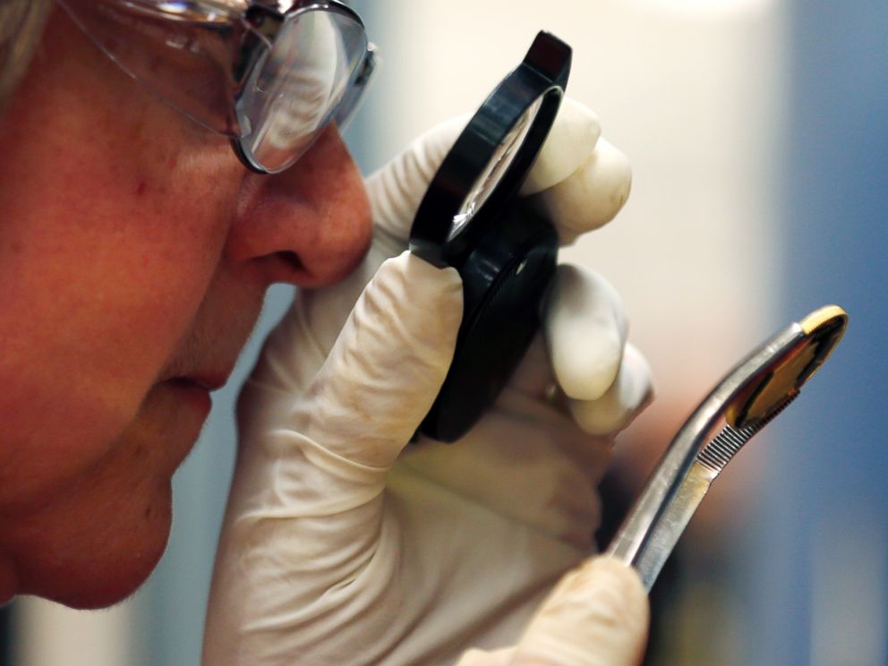 PHOTO: Press operator Migdalia Velazquez inspects a newly-stamped gold coin of President John F. Kennedy at the U.S. Mint at West Point on July 22, 2014 in West Point, N.Y.