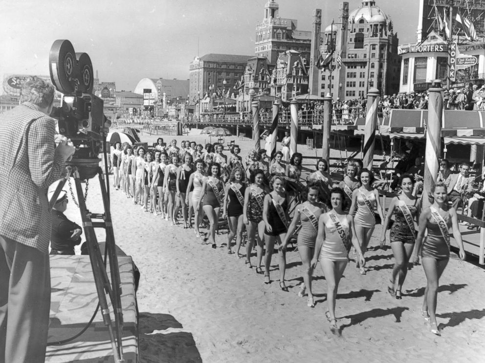 PHOTO: A cameraman films contestants in the Miss America Pageant as they walk on the beach next to the boardwalk at Atlantic City, N.J., Jan. 9, 1939.
