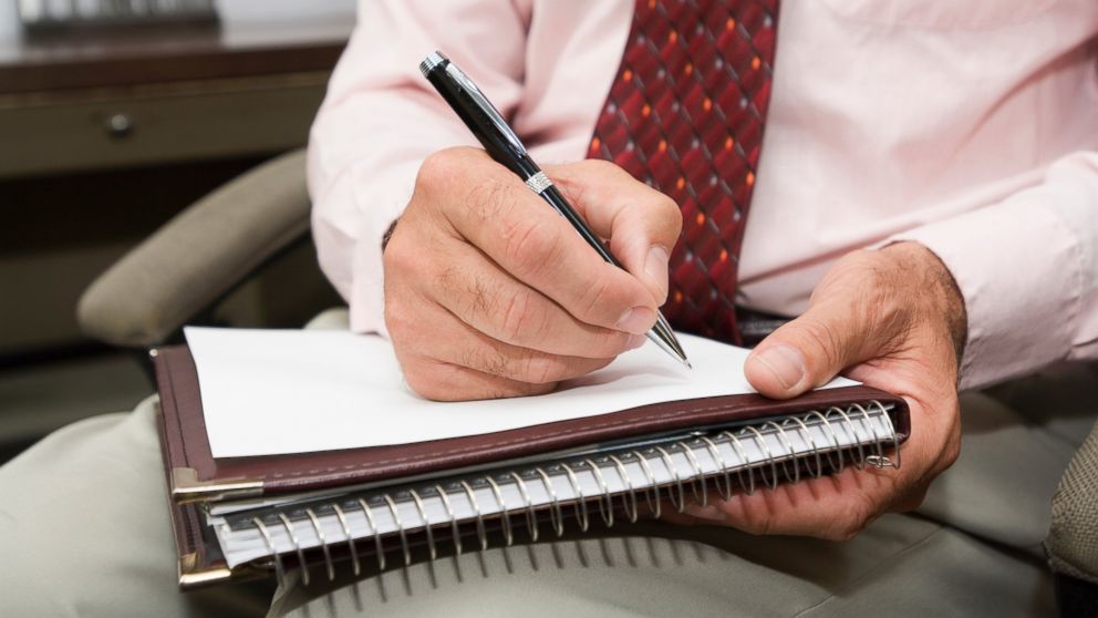 PHOTO: A psychologist jots down some notes with a pen while in session with a client.