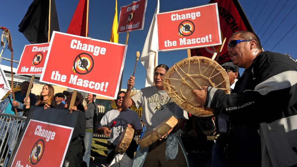 PHOTO: Protesters sing and play the drums outside of Sports Authority Field at Mile High in Denver