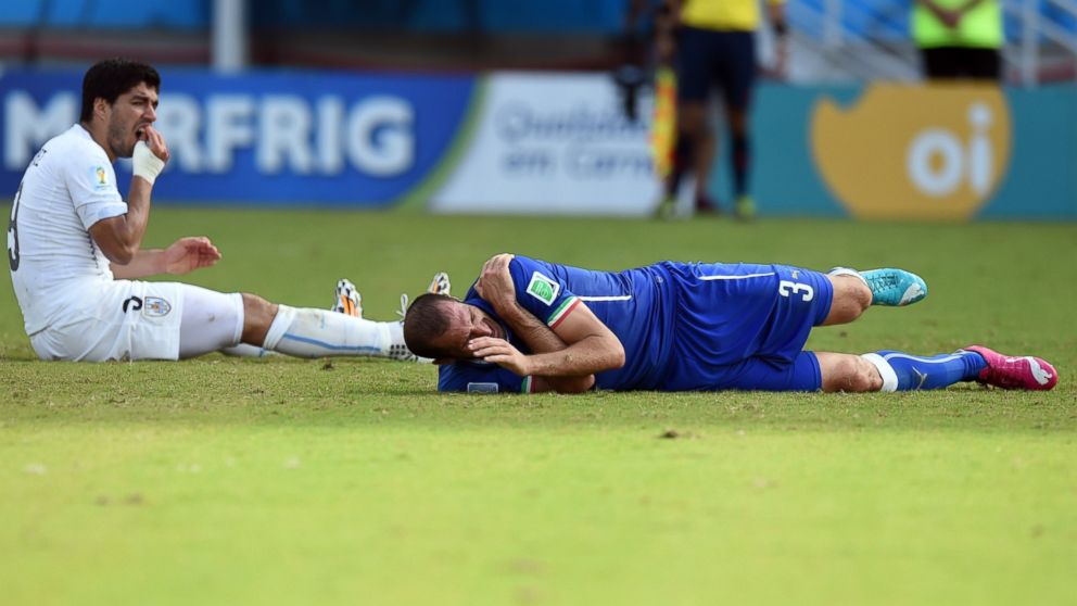 PHOTO: Uruguays forward Luis Suarez left, reacts past Italys defender Giorgio Chiellini during a Group D football match between Italy and Uruguay at the Dunas Arena in Natal during the 2014 FIFA World Cup on June 24, 2014. 