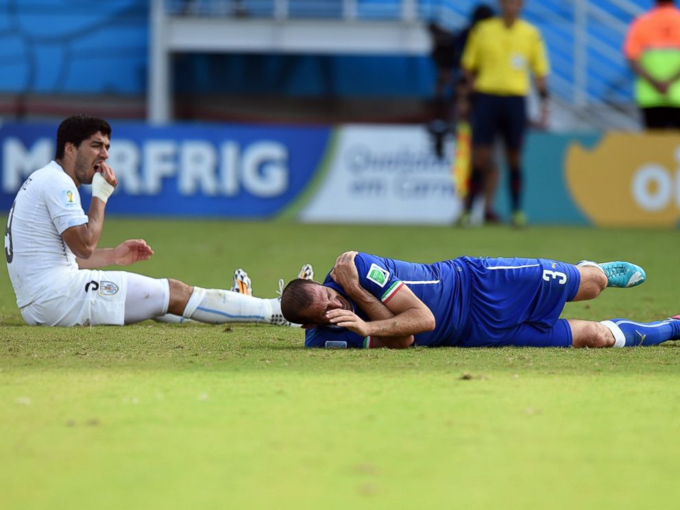 PHOTO: Uruguays forward Luis Suarez left, reacts past Italys defender Giorgio Chiellini during a Group D football match between Italy and Uruguay at the Dunas Arena in Natal during the 2014 FIFA World Cup on June 24, 2014.