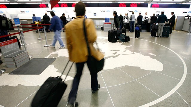 PHOTO: In this file photo, passengers approach the check-in counter at the Minneapolis St. Paul International Airport in Minneapolis.