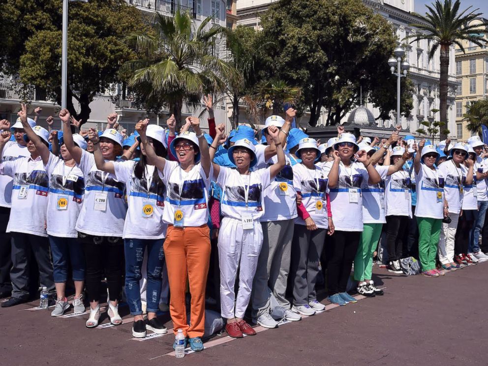 PHOTO: Employees of Chinese company Tiens attend a parade on the Promenade des Anglais in Nice, southeastern France, May 8, 2015.