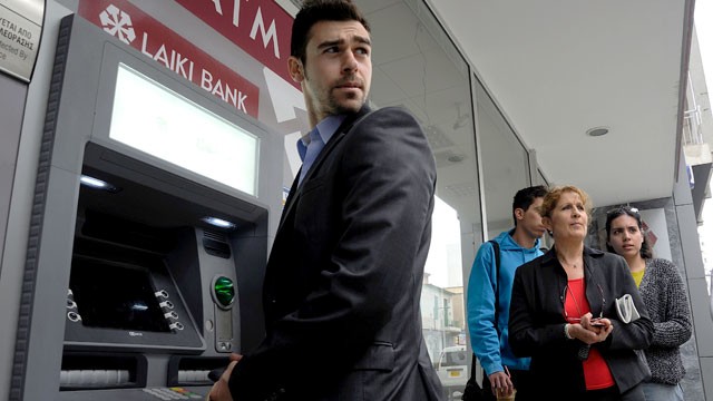 PHOTO: People wait to use the ATM of a closed branch of Laiki Bank in southern port city of Limassol, Cyprus on March 21, 2013.