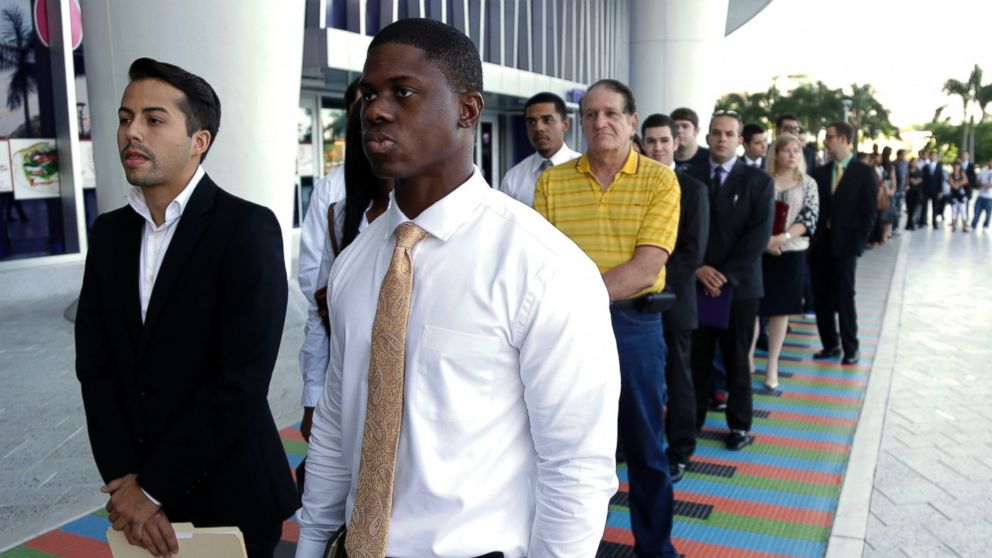 PHOTO: In this Oct. 23, 2013 file photo, Luis Mendez, left, and Maurice Mike,wait in line at a job fair held by the Miami Marlins, at Marlins Park in Miami.
