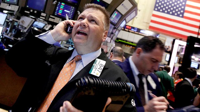 PHOTO: Trader George Ettinger, left, works on the floor of the New York Stock Exchange, June 11, 2012.