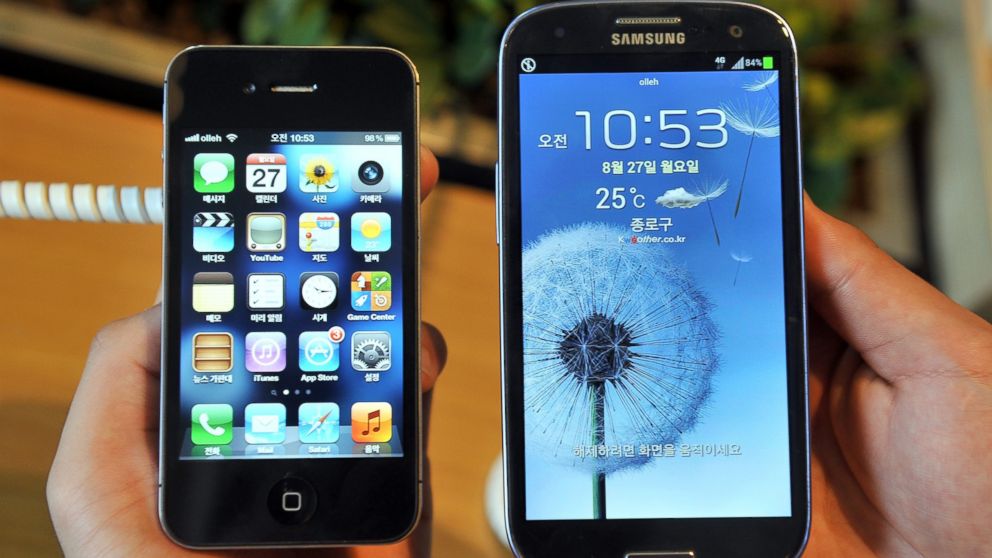 PHOTO: An employee shows an Apples iPhone 4s (L) and a Samsungs Galaxy S3 (R) at a mobile phone shop in Seoul on August 27, 2012.