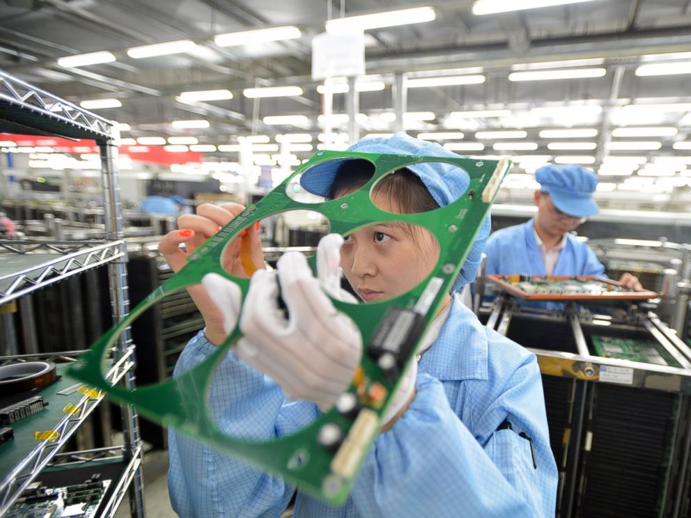 PHOTO: Employees work on the production line of a telecom equipment manufacturer on July 27, 2015 in Wuhan, China.